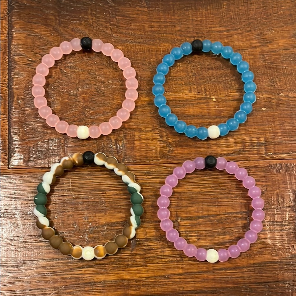 Like NEW Set of 4 Water Lokai Bracelets in Pink, Blue, Purple, and Camo.